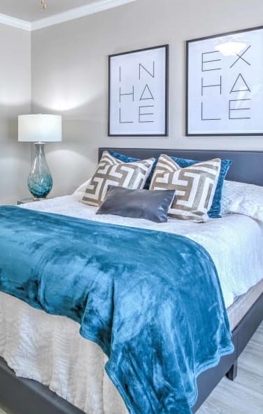 a bedroom with a bed and some pictures on the wall at The Atlantic McKinney Ranch, Texas, 75070