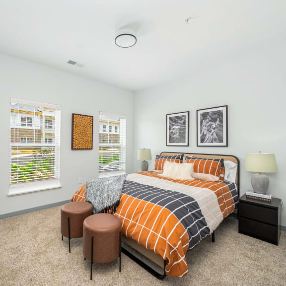 a bedroom with a bed and two windows