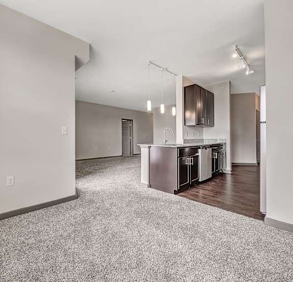  A spacious living room with a kitchen area in the background. at River Crossing Apartments, St. Charles, MO, 63303
