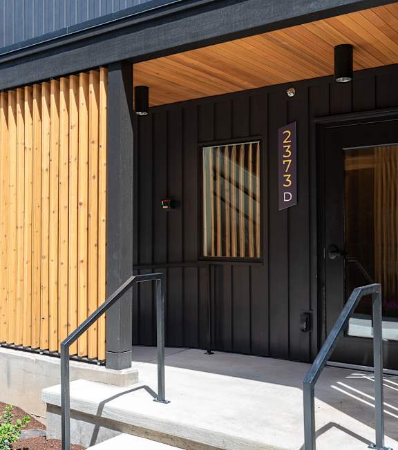 A black and wooden building with the number 2373D on the door.