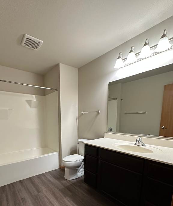 A modern bathroom with a walk-in shower and a wooden ceiling.