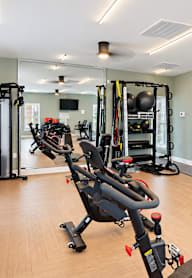 A gym with a variety of equipment including treadmills, weights, and exercise machines.