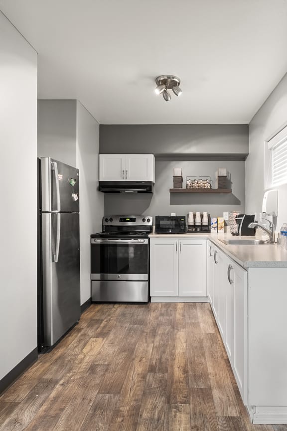 a kitchen with white cabinetry and stainless steel appliances at Mill Pond Apartments, Auburn, WA