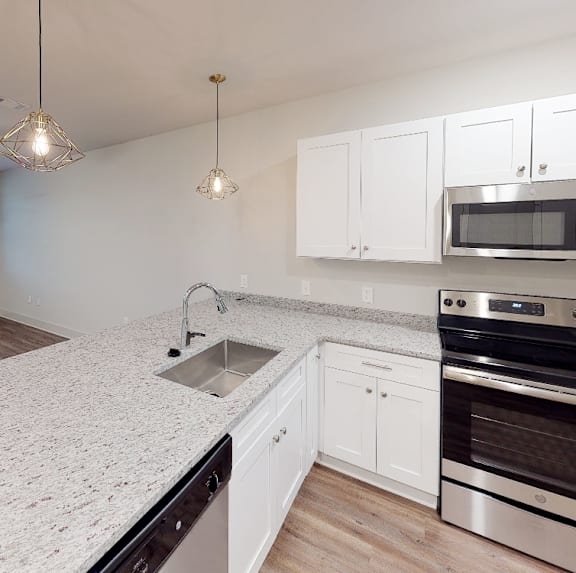 a kitchen with white cabinets and a counter top at Midtown Row, Montgomery