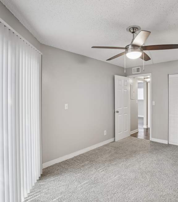 A room with a ceiling fan and a carpeted floor.