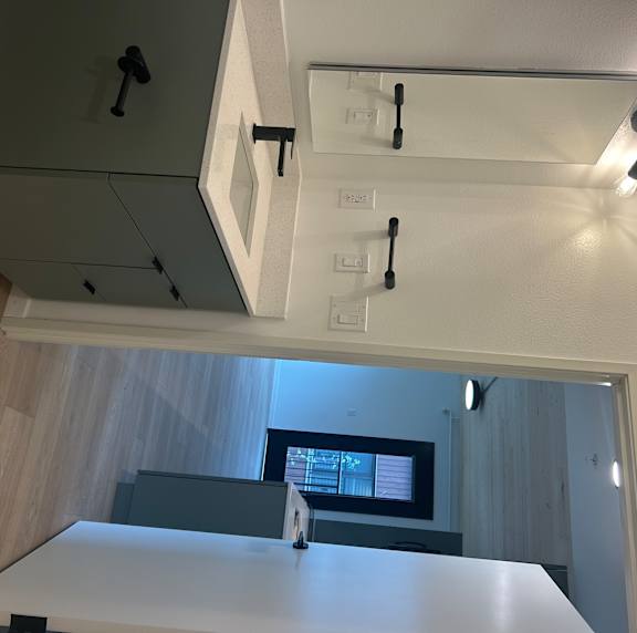 A bathroom with a mirror, light, and a window.