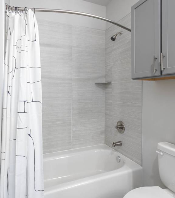 A white bathroom with a toilet, sink, and bathtub. A white bathroom with a toilet, sink, and bathtub. at Viridian Apartments LLC Apartments, Bowling Green