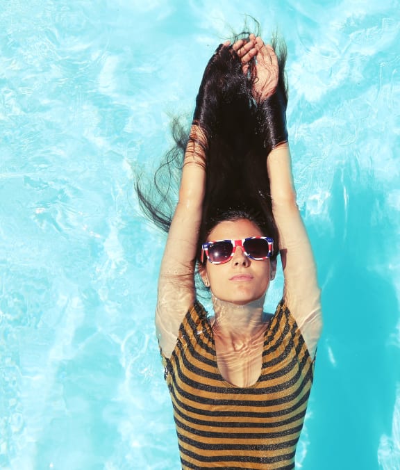 a woman laying in a pool with her hair in the water