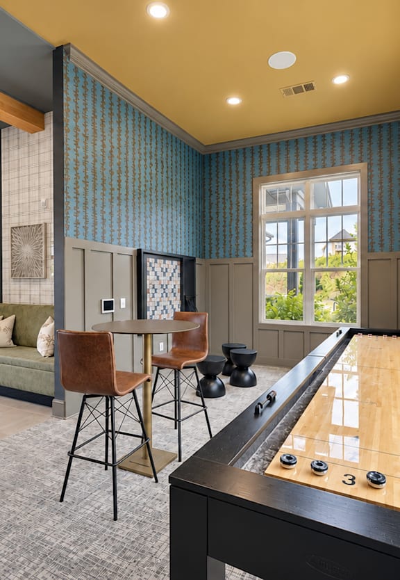 A pool table is in the middle of a room with a chair and a couch.