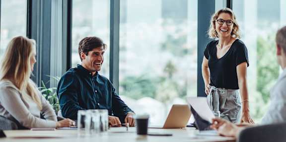 a group of people sitting around a table in a meeting room