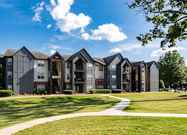 Wesley St. Claire Apartments at Lawrenceville exterior of apartment building with lawn and walkway - Lawrenceville, GA