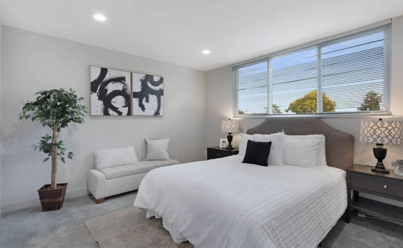 a bedroom with a large bed next to a window
