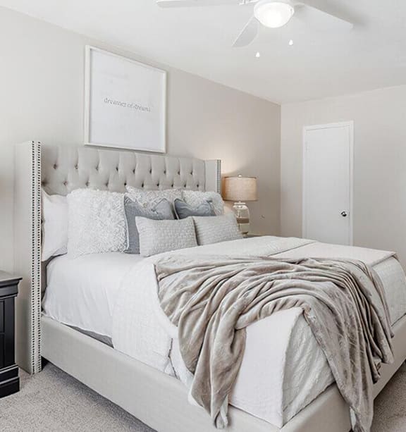 a bedroom with a bed and a ceiling fan