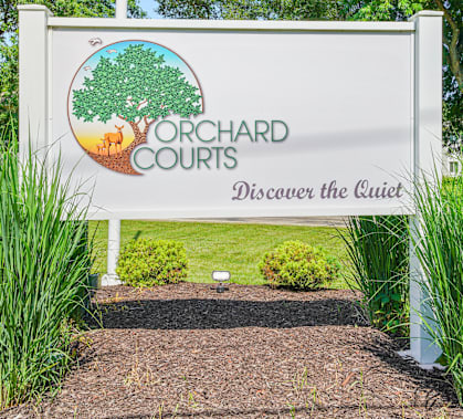 A sign for Yorchard Courts with a tree on it.