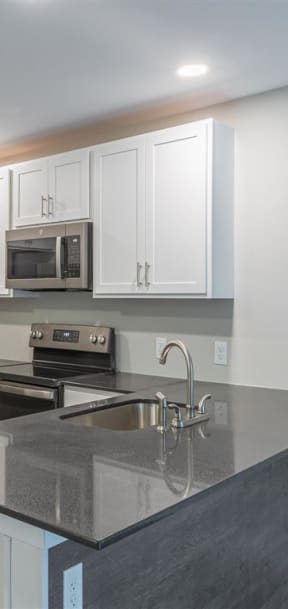 a kitchen with white cabinets and a black stove and refrigerator