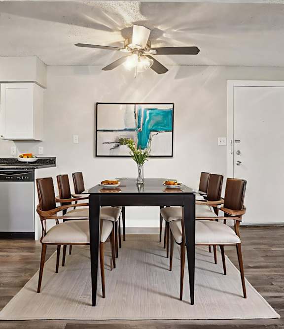 A dining room with a table set for six.
