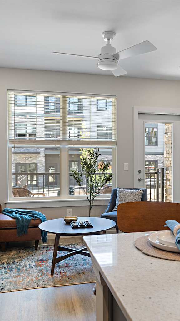 A room with a bench, picture, and framed objects on the wall.