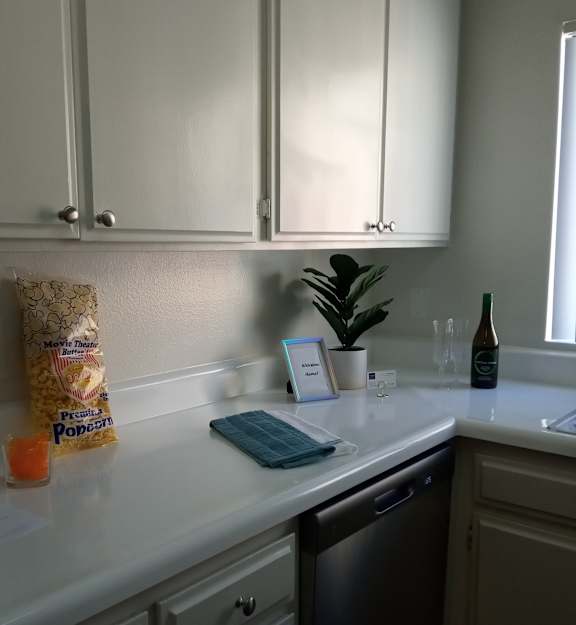 A modern kitchen with a black countertop and white cabinets.