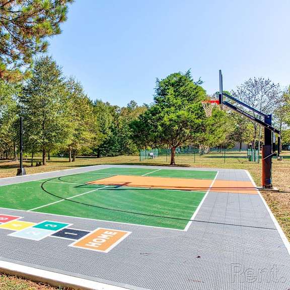 A basketball court with a green, orange, and blue surface.