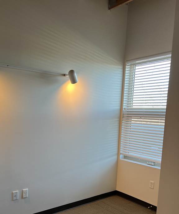 a light on the floor of a room with a window