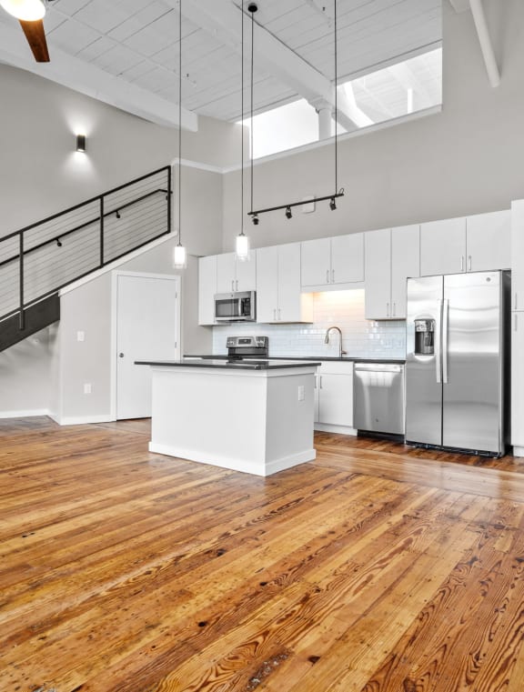 an open living room and dining room with a ceiling fan at Spinning Mill Lofts, Clayton, NC 27520
