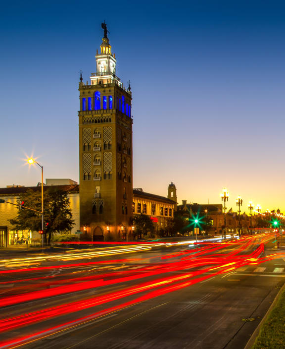 a city at night with a clock tower in the background