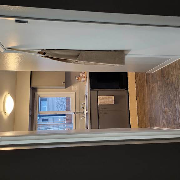 an empty room with a bath tub and a refrigerator in it