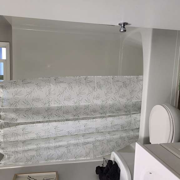 a small bathroom with a shower and a toilet and a towel rack