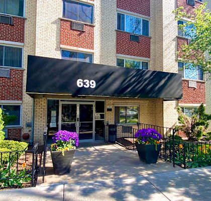 The entrance to apartment building 639 is shown with a black awning and flower pots in front.