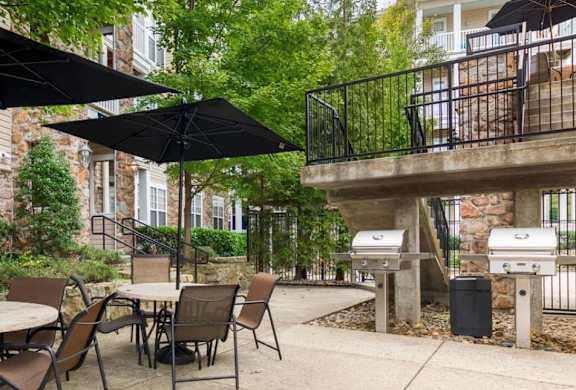 A patio with a table and chairs under umbrellas.