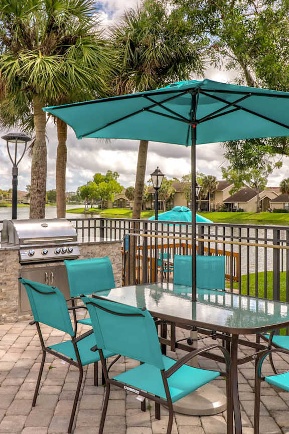 A patio with a table and chairs under an umbrella.