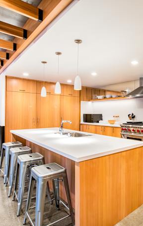A modern kitchen with wooden cabinets and a large island.at The Rise, San Francisco, CA 94103