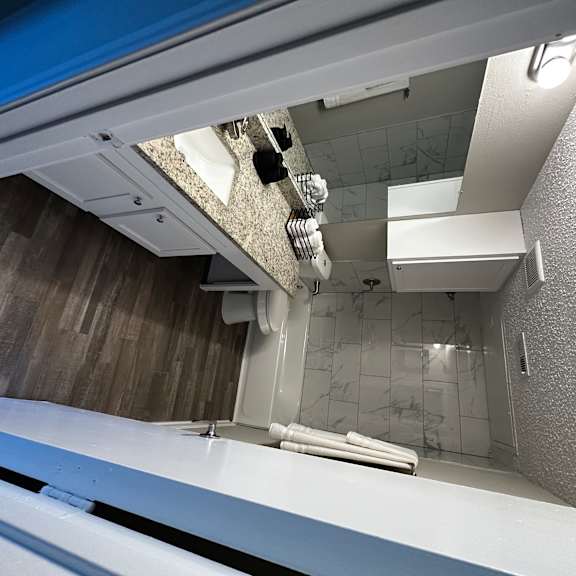 A bathroom with a toilet, sink, and mirror.
