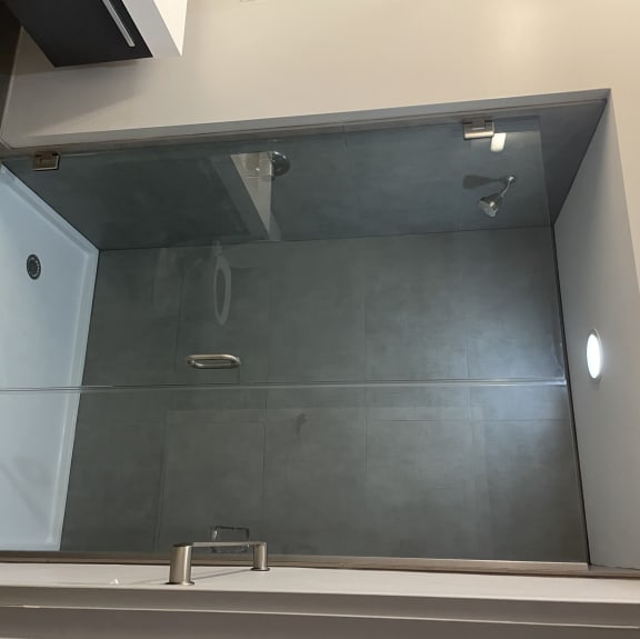 Large spacious bathrooms feature ample lighting, floating vanities, and large showers with full glass doors.