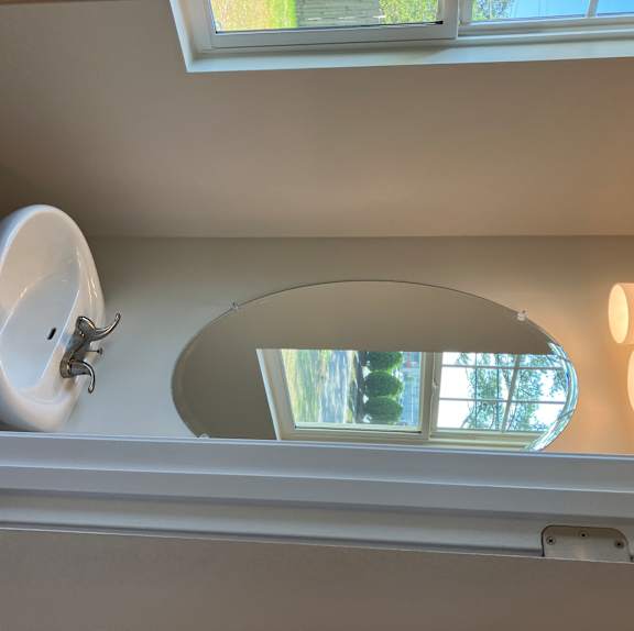 A white ceiling with a light fixture and a window.