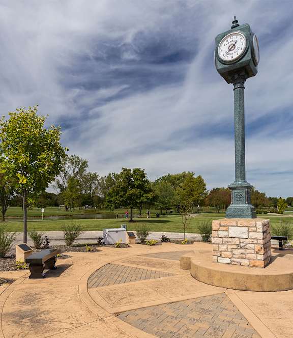 a clock tower in the middle of a park with benches