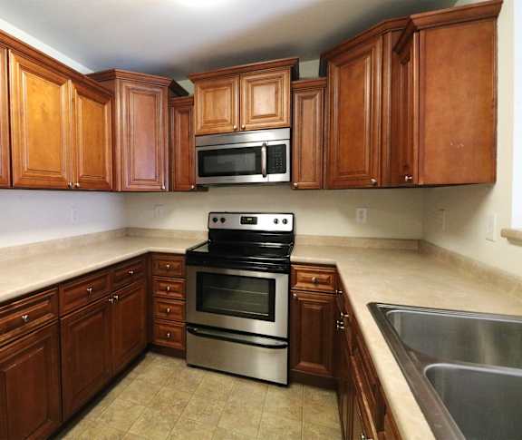 a small kitchen with a counter and a stainless steel refrigerator