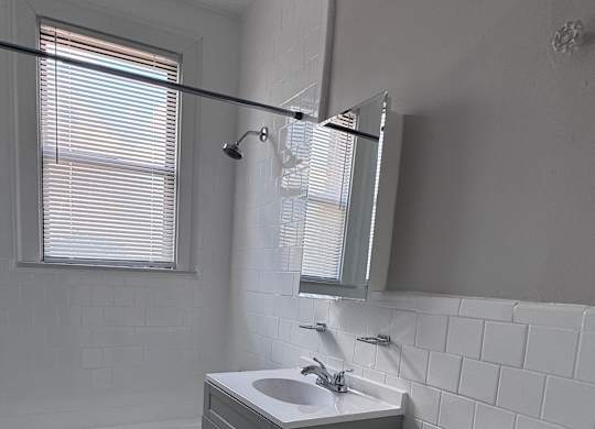 A bathroom with a toilet, sink, and a window.