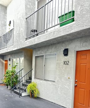 a view of a courtyard with stairs and an orange door at The Marq Apartments LLC, Los Angeles