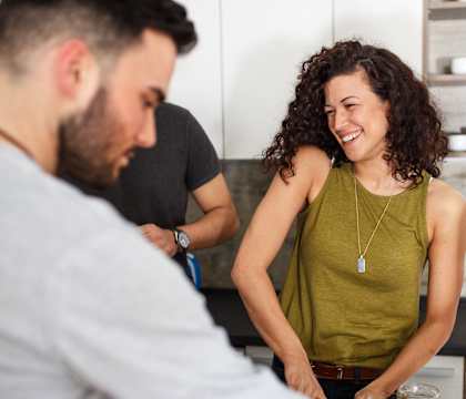 A man and two women are preparing food together in a kitchen.