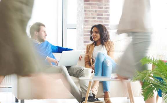 A group of people are walking in a brightly lit room.