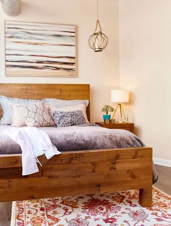 a bedroom with a wooden bed and a painting on the wall