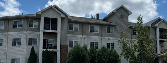 A large apartment complex with a grassy area in front.