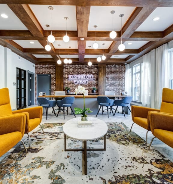 a lobby with yellow couches and chairs and a table