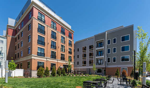 a courtyard with tables and chairs in front of an apartment building at Union 346, Somerville, MA