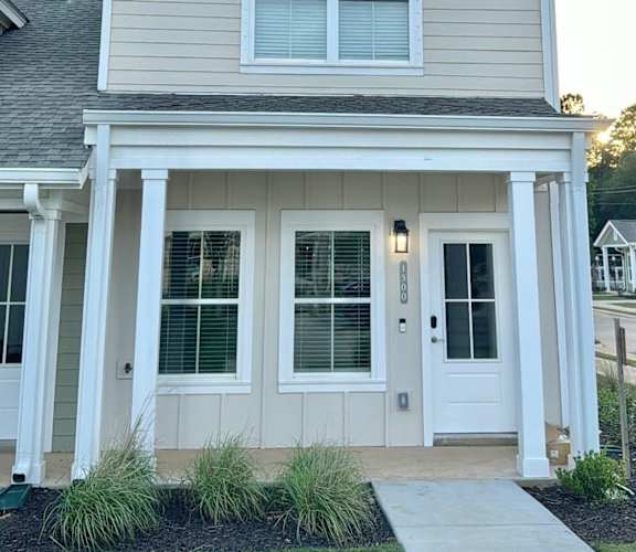 A small house with a front porch and a white door.