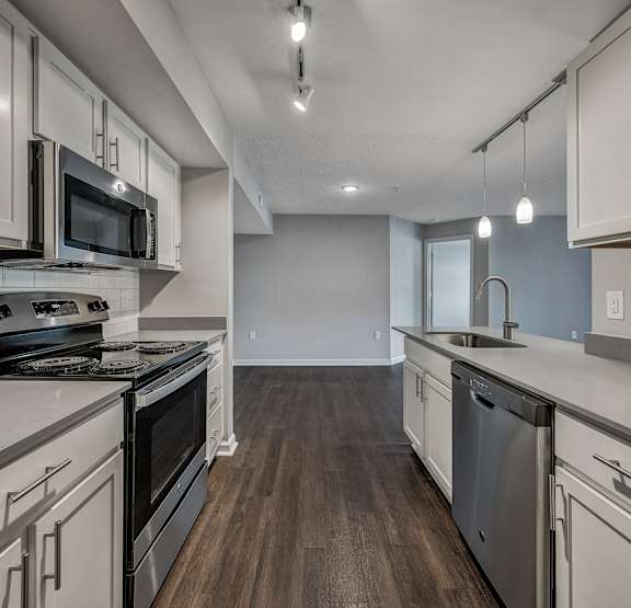  A kitchen with white cabinets and dark floors at Sunscape Apartments, Roanoke, Virginia
