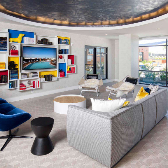 a living room with a couch and chairs and a television at The Enclave, Jersey City, New Jersey