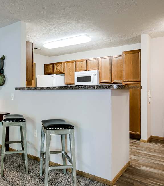 A kitchen with a table and chairs.