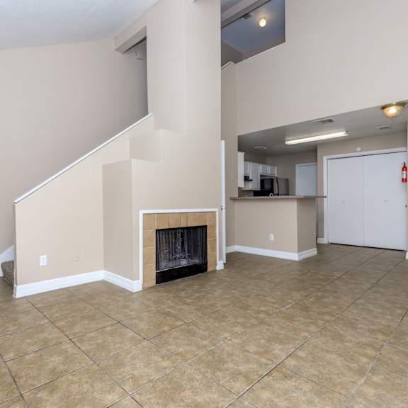 A room with a fireplace and tile flooring.